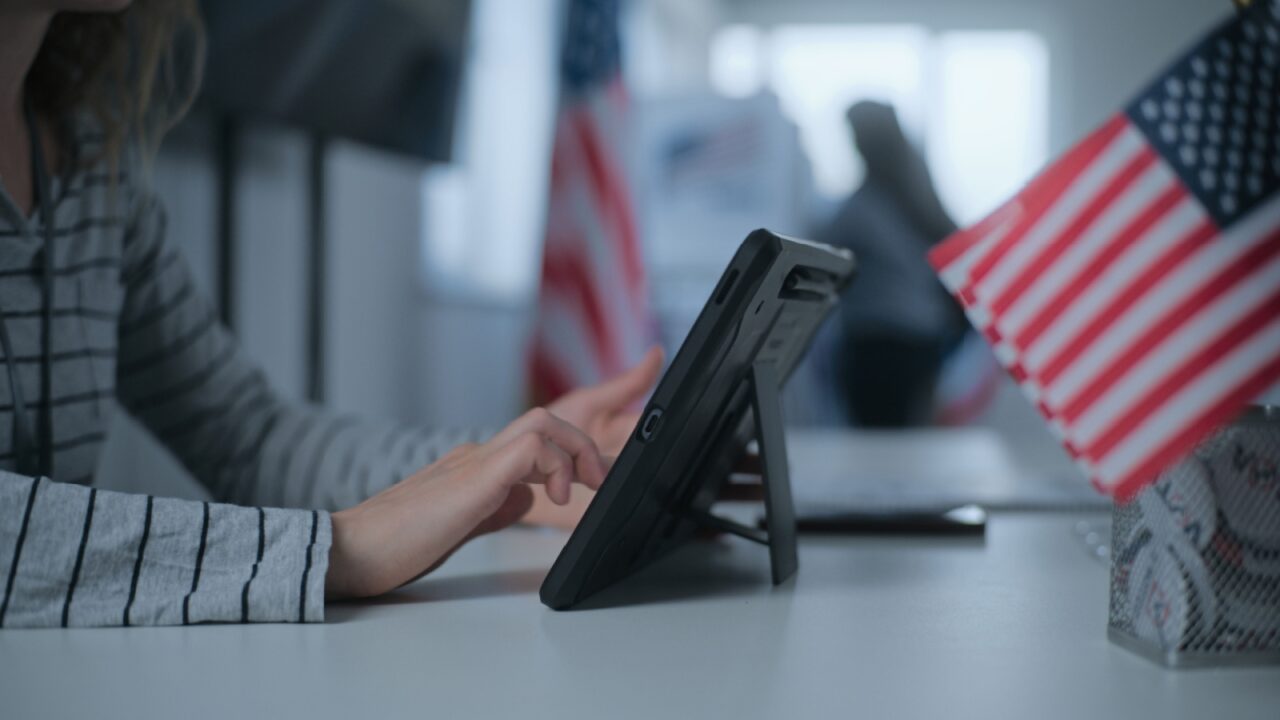 Female polling officer sits at registration table at polling station