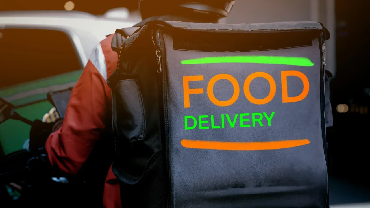 a man and motorcycle food delivery service in city