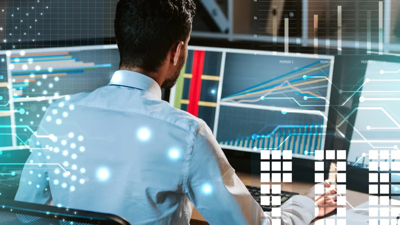 back view of trader working near computer with graphs