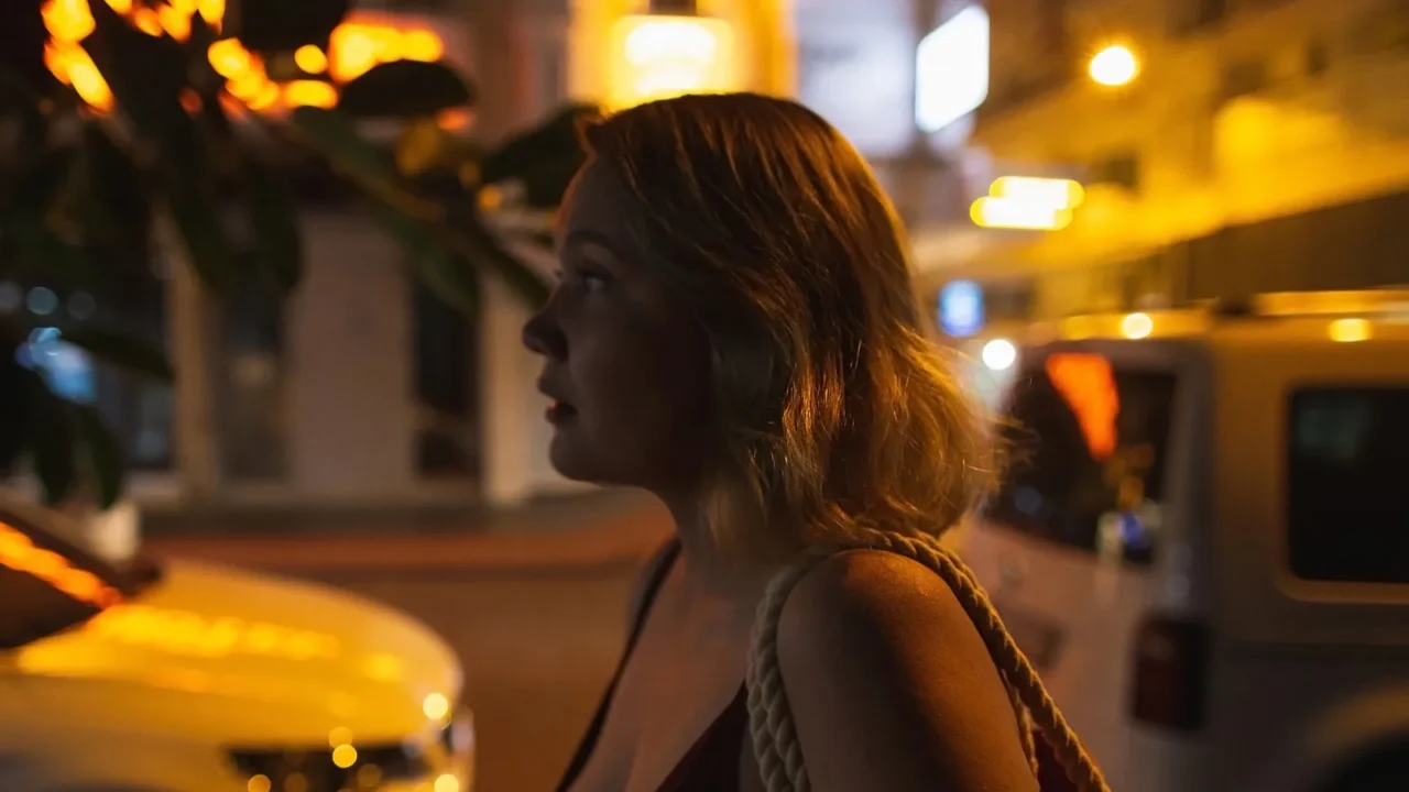 beautiful busty blonde woman walking in the dark night city