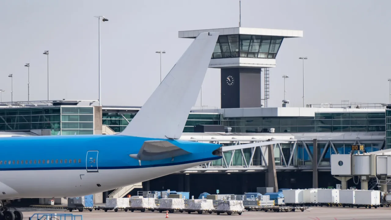 blue and white jet tail near airport terminal and control