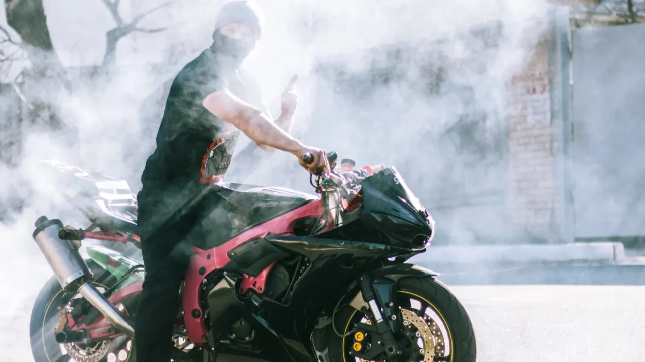 burnout on stunt motorcycle with bright sun on background