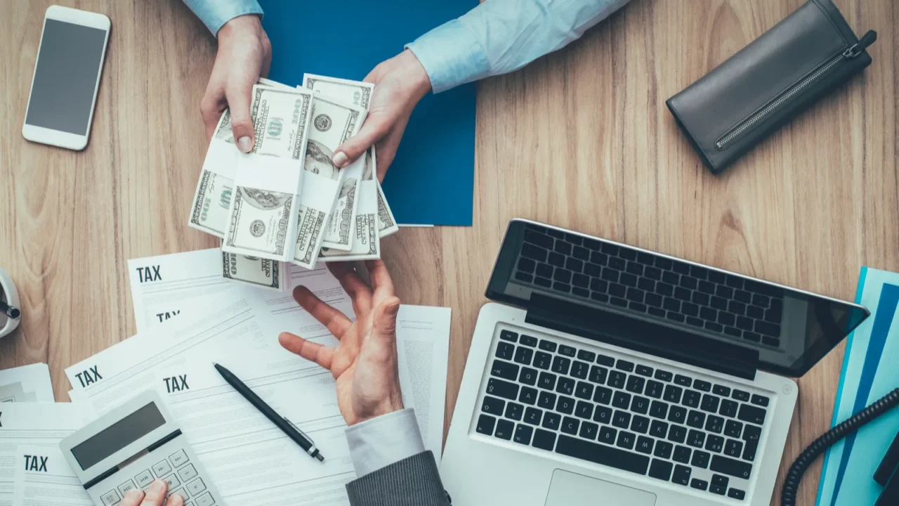 business woman giving packs of dollars