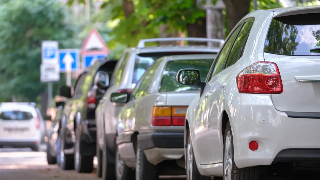 city traffic with cars parked in line on street side