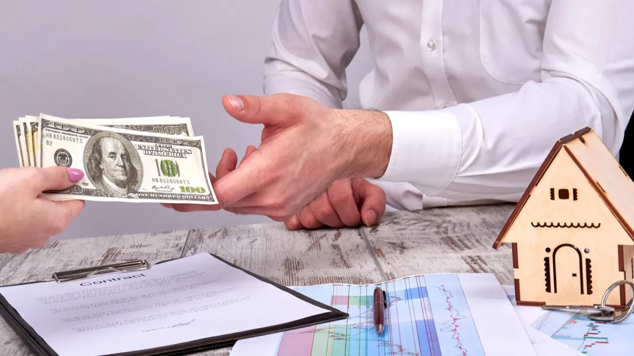 close up female hands giving cash money to a realtor