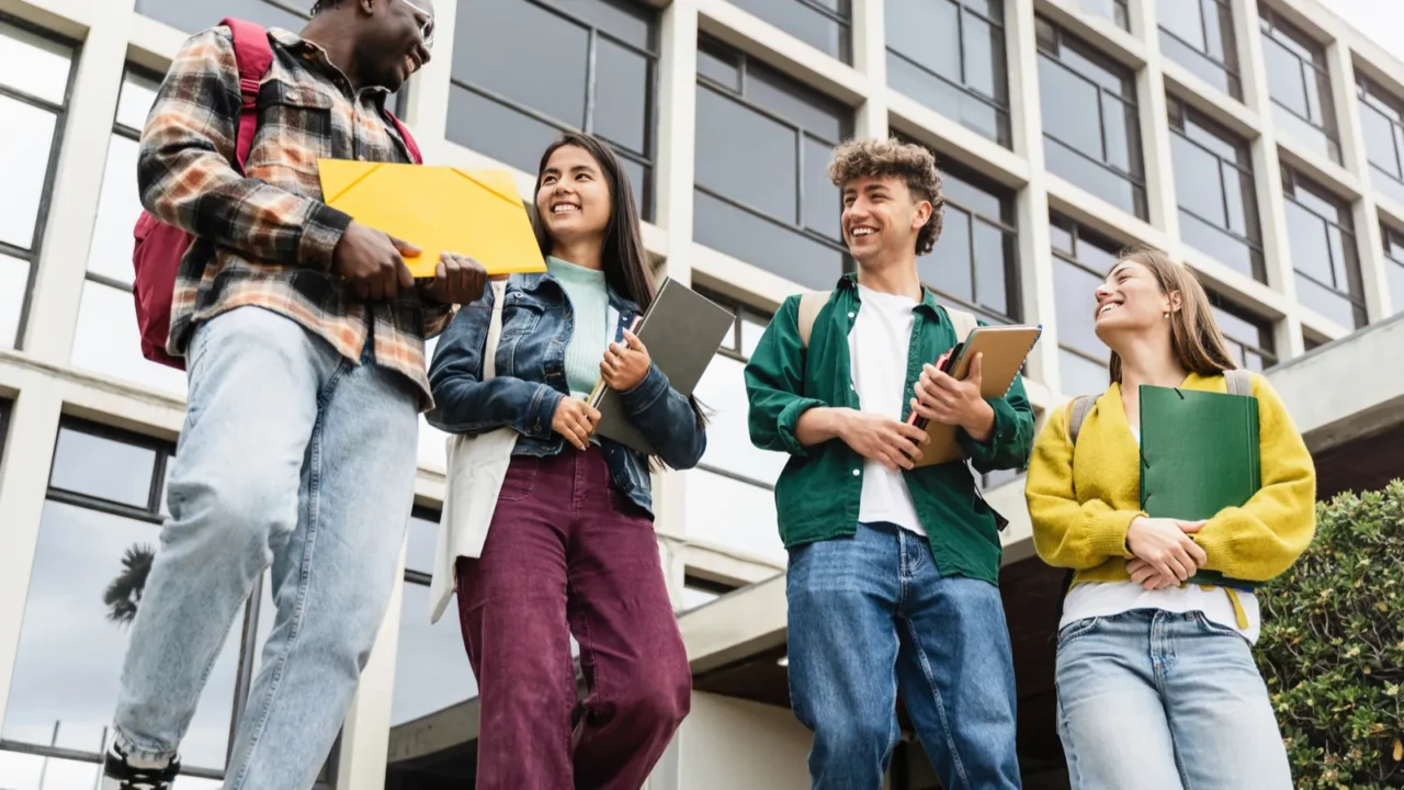 college students walking university staircase talking and laughing after lectures