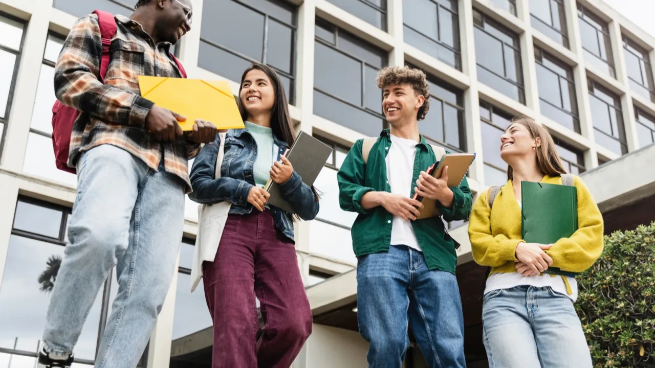 college students walking university staircase talking and laughing after lectures