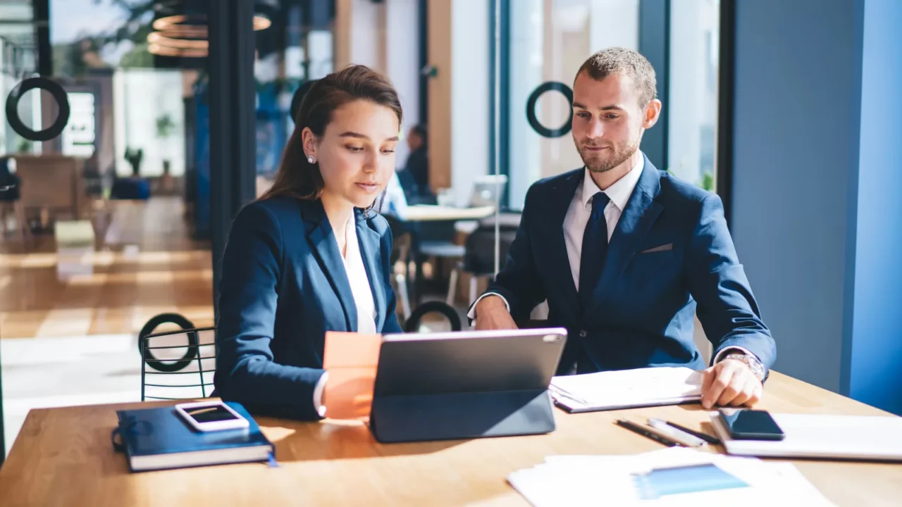 confident male and female entrepreneurs using digital tablet for online