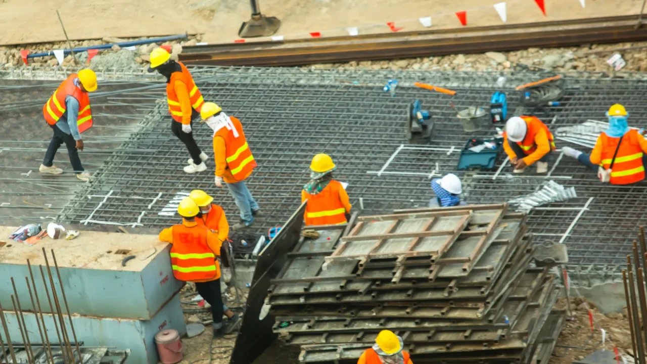 construction workers are working on steel structures to prepare concrete
