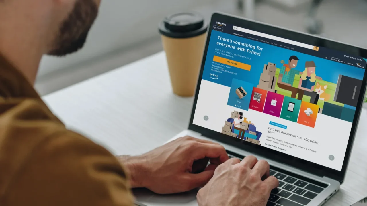 cropped view of man using laptop with amazon website on