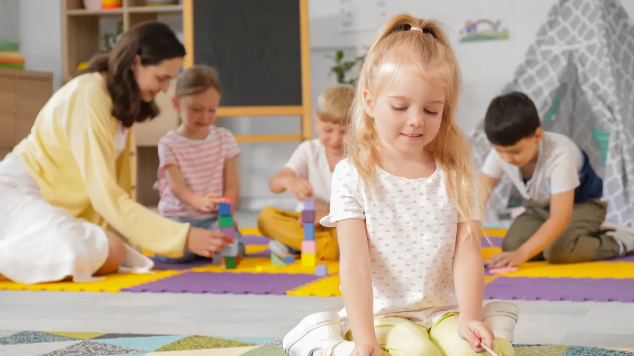 cute little girl playing xylophone in kindergarten