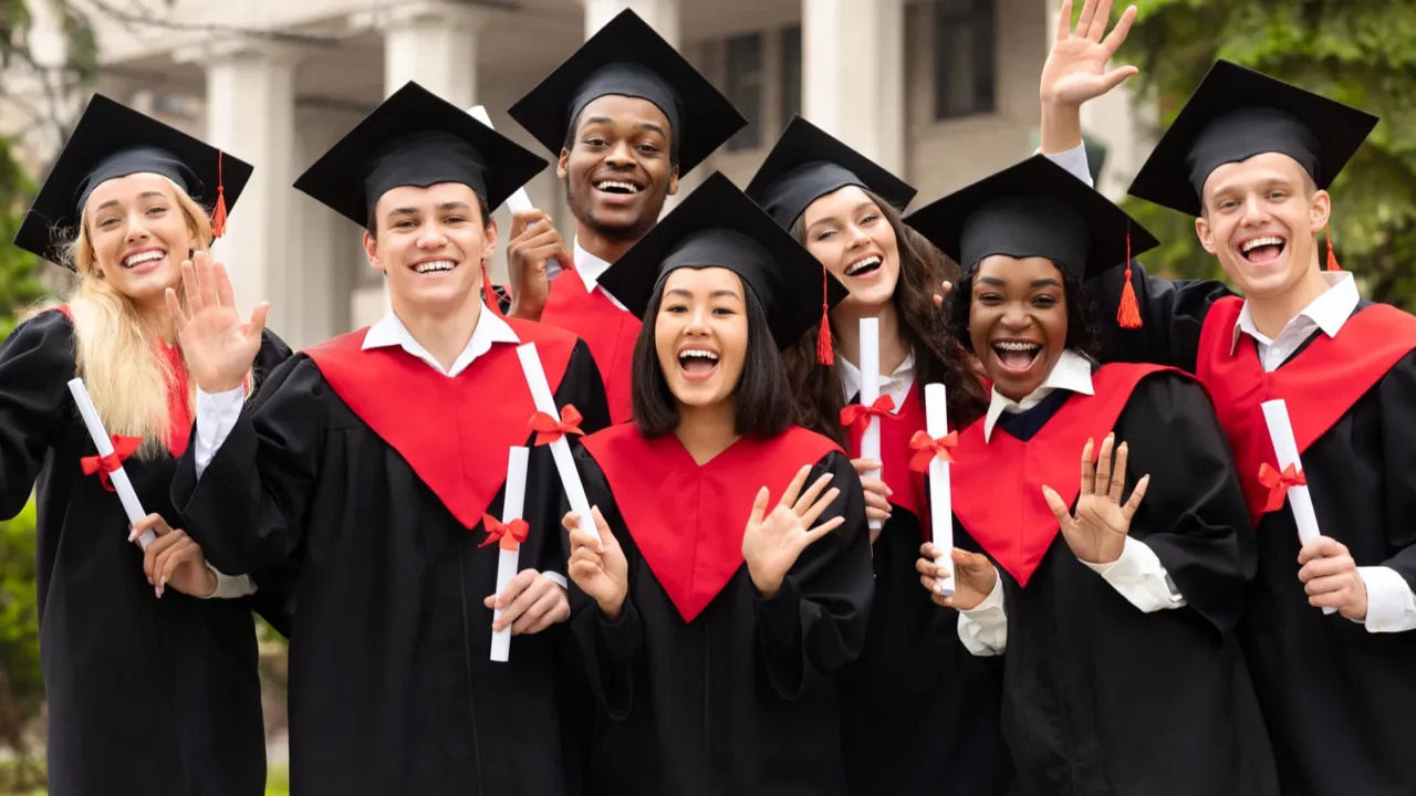 diverse international students with diplomas celebrating graduation waving at camera
