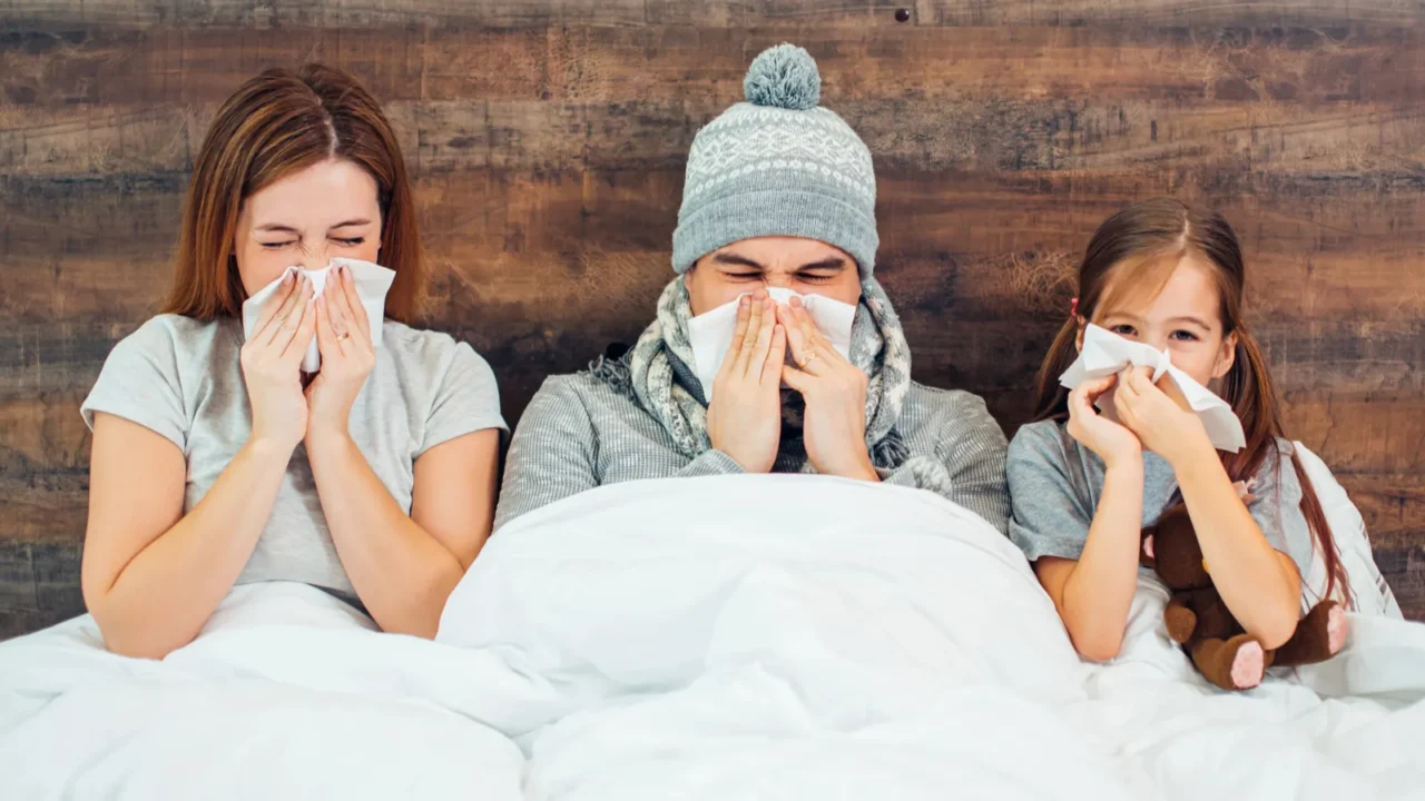 family health and people concept ill family on bed at