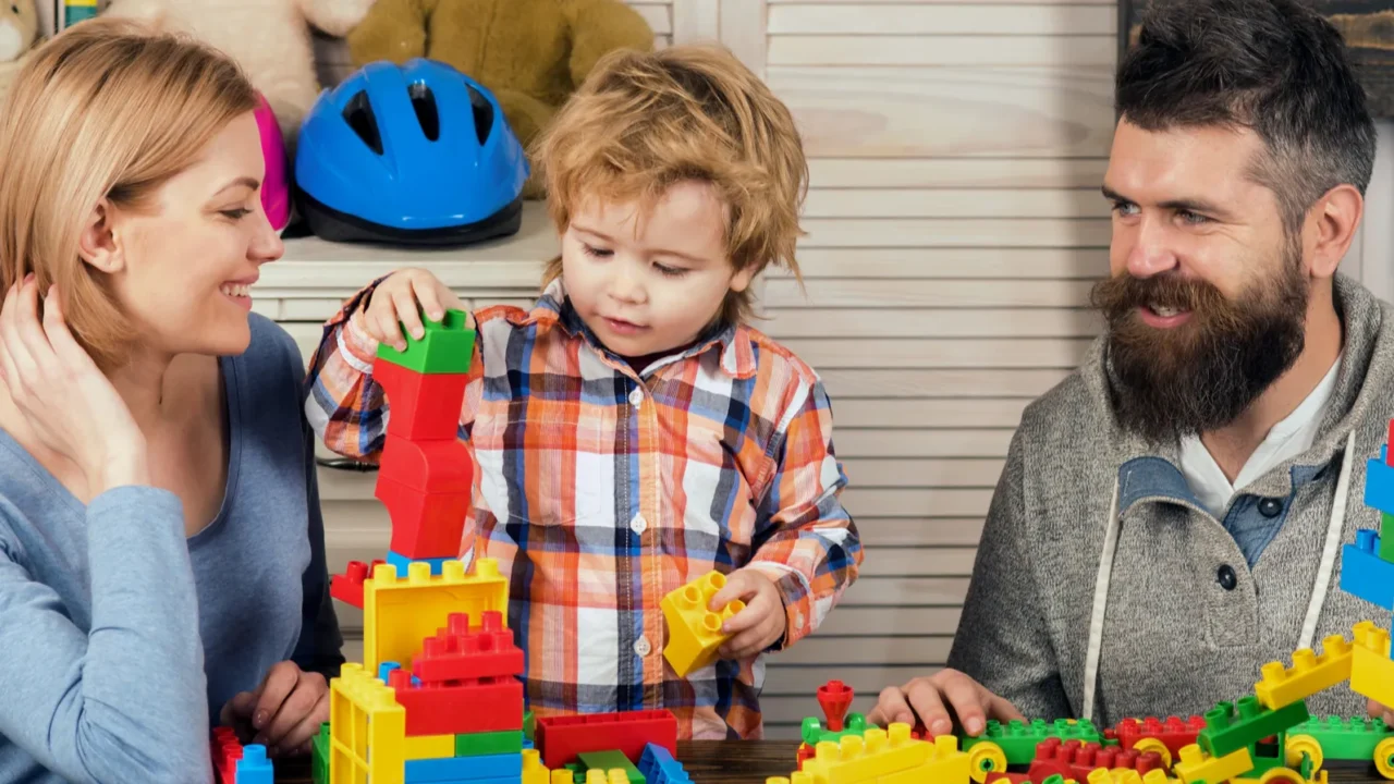 family playing with colorful plastic building blocks at home happy