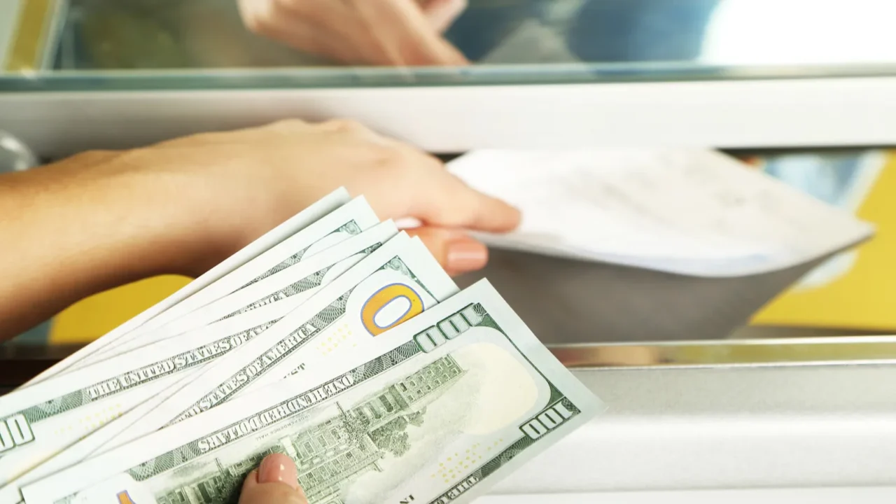 female hand with money in cash department window currency exchange