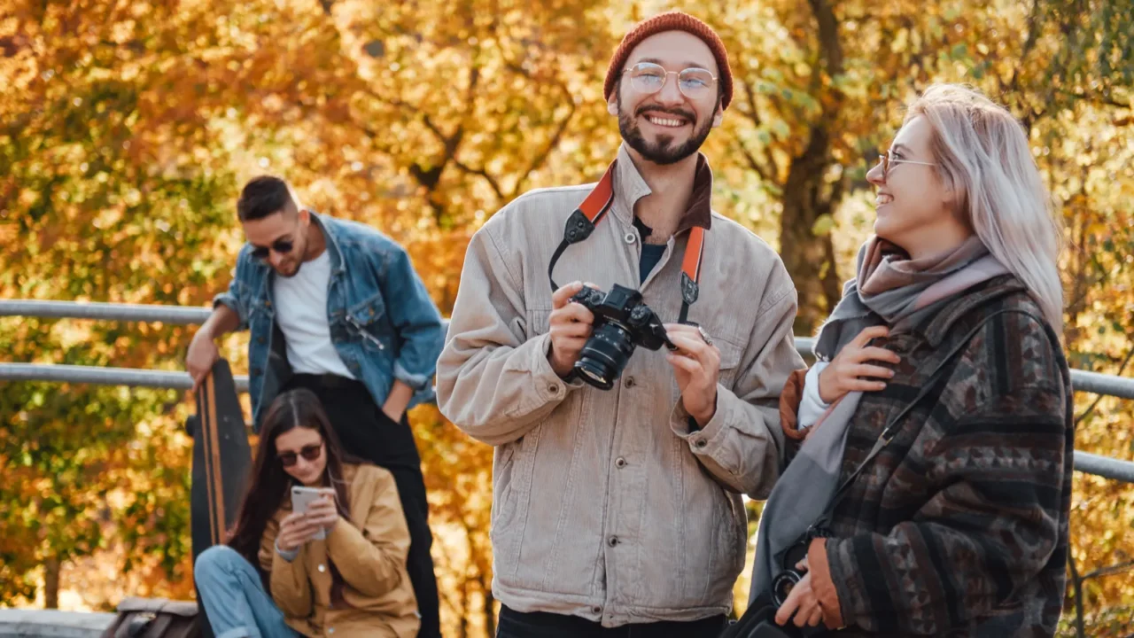 four friends spending holidays together in autumn park
