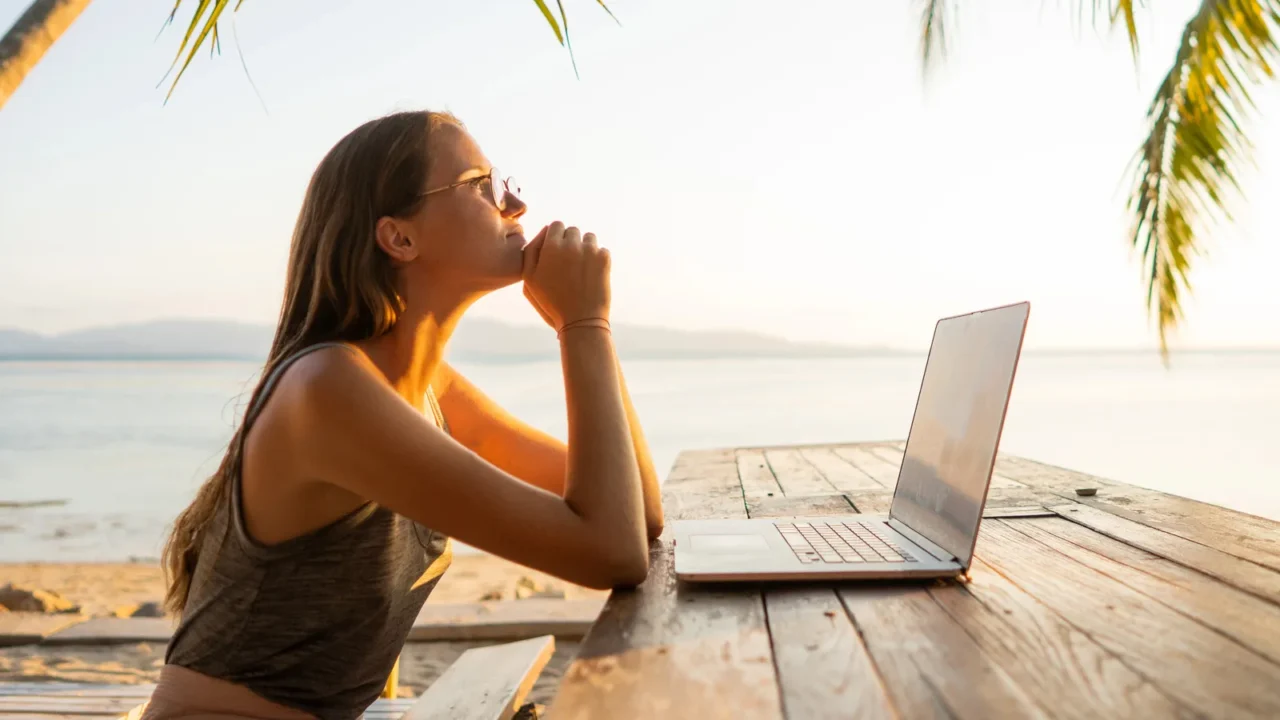 freelancer girl with a computer among tropical palm trees work