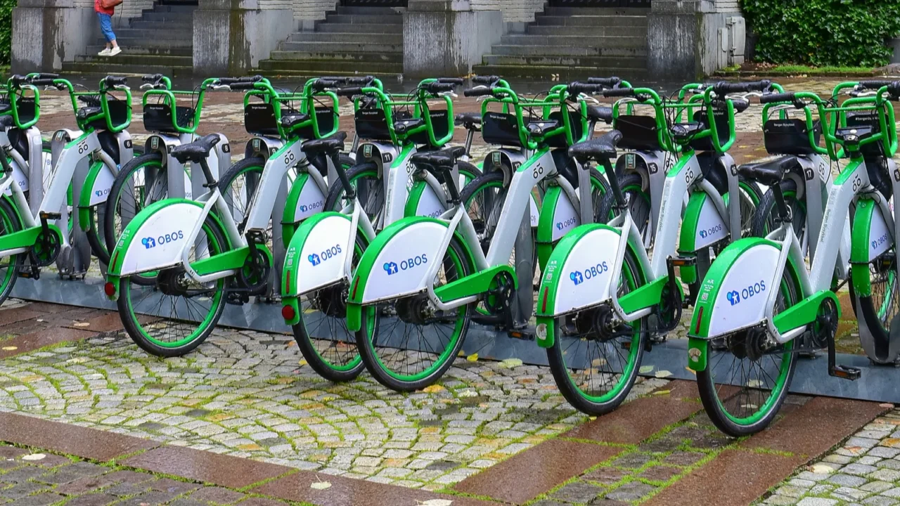 green electric city bikes parked and charging at bicycles sharing