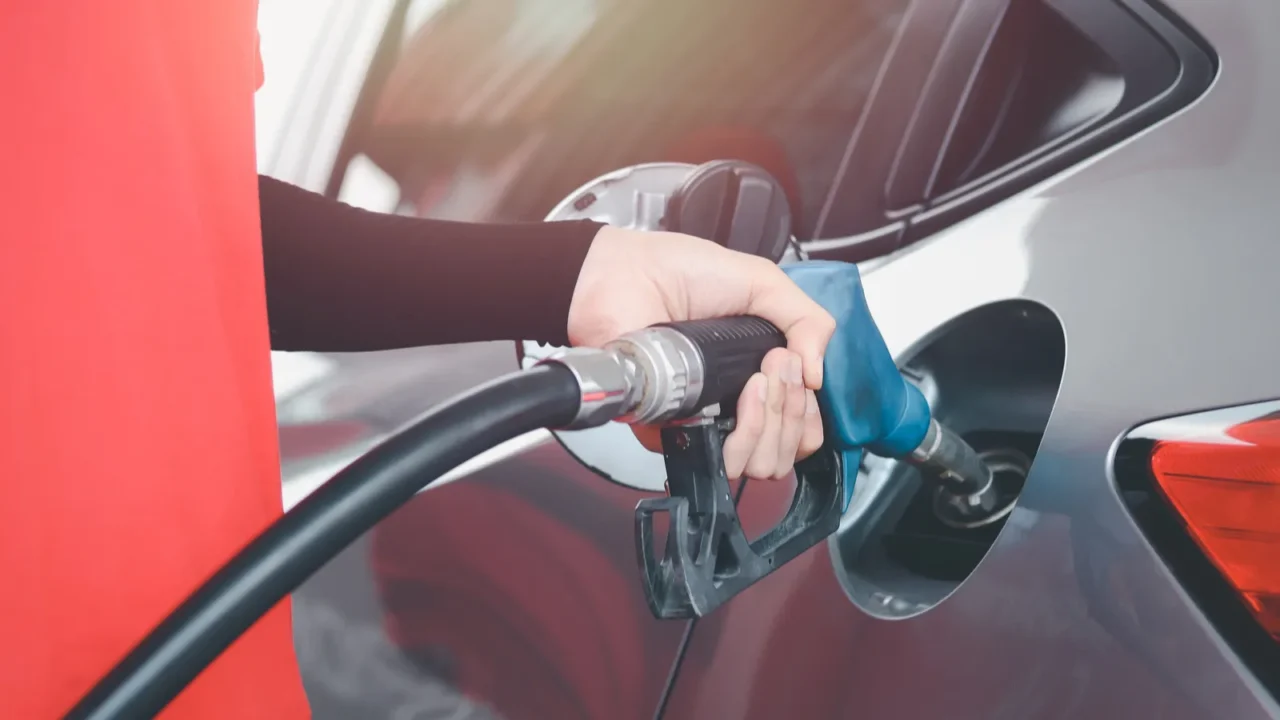 hand of gas station attendant holding a fuel petrol pump
