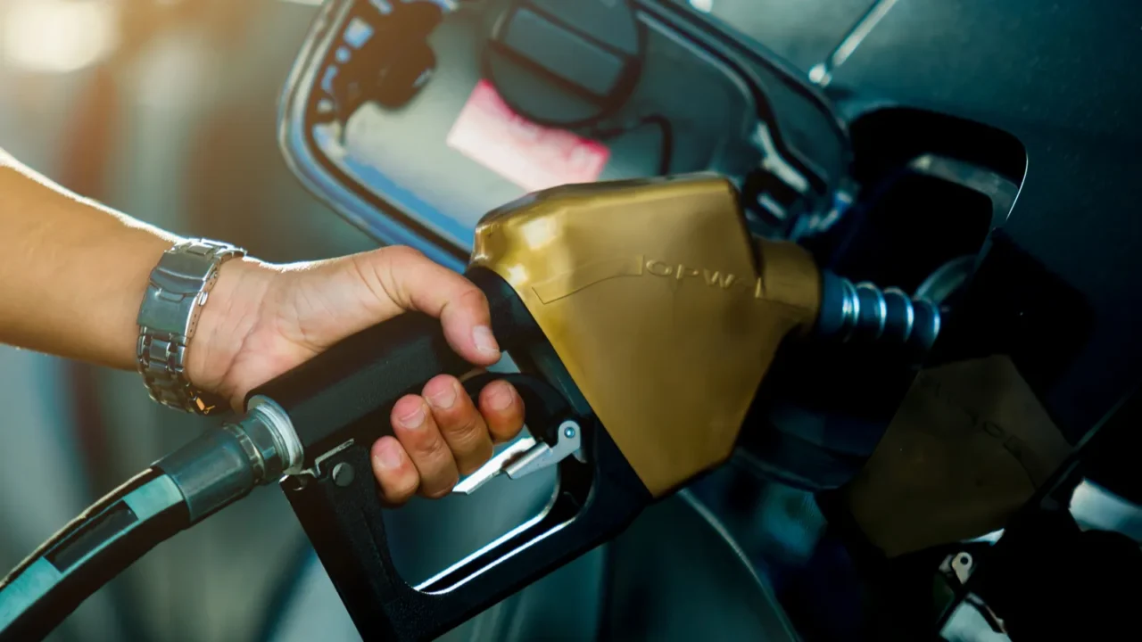 hand refilling the car with fuel at the refuel station