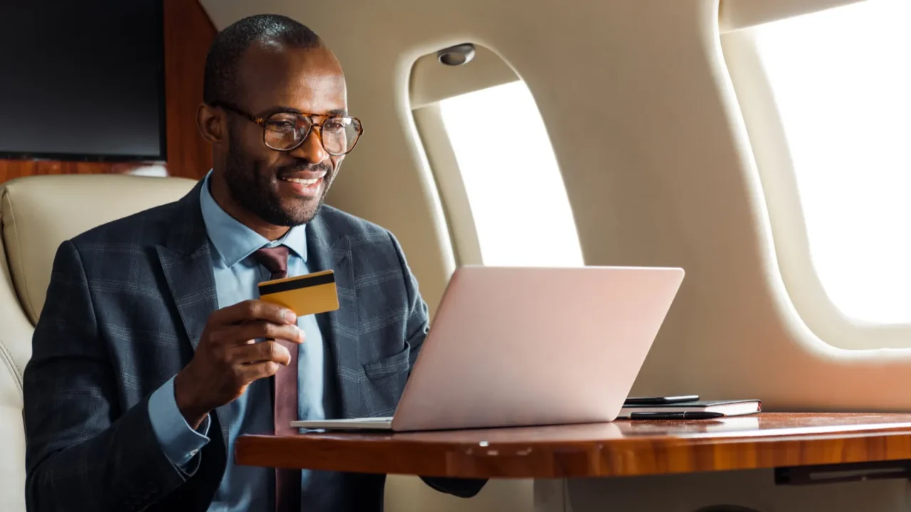 happy african american businessman in glasses holding credit card near