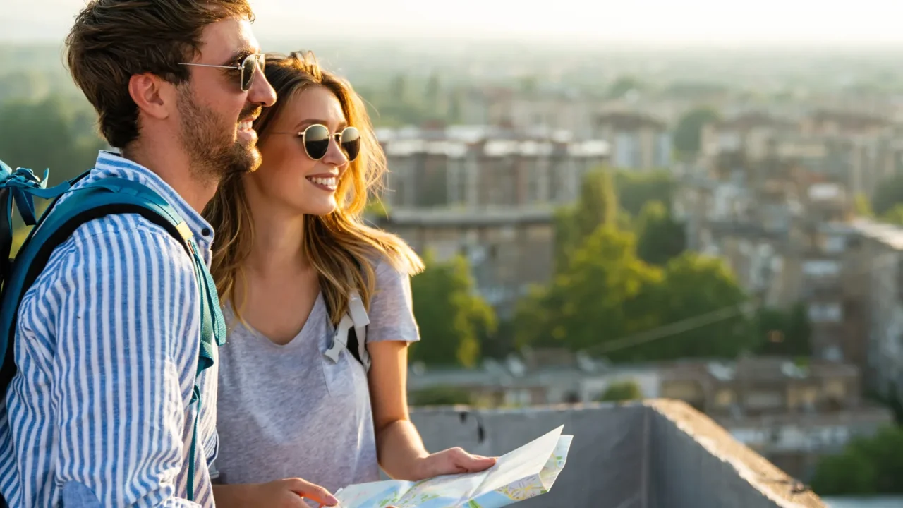 happy smiling couple on vacation sightseeing city with map people