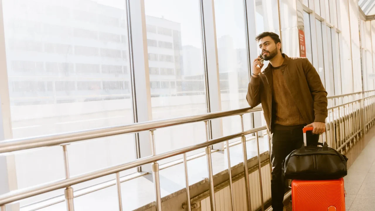 indian bearded man talking on mobile phone at train station