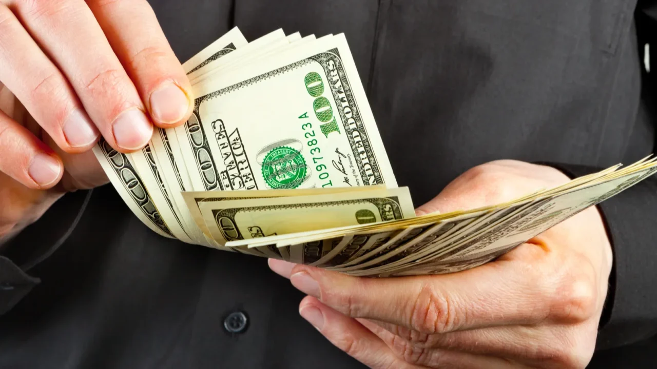 man counts money in hands