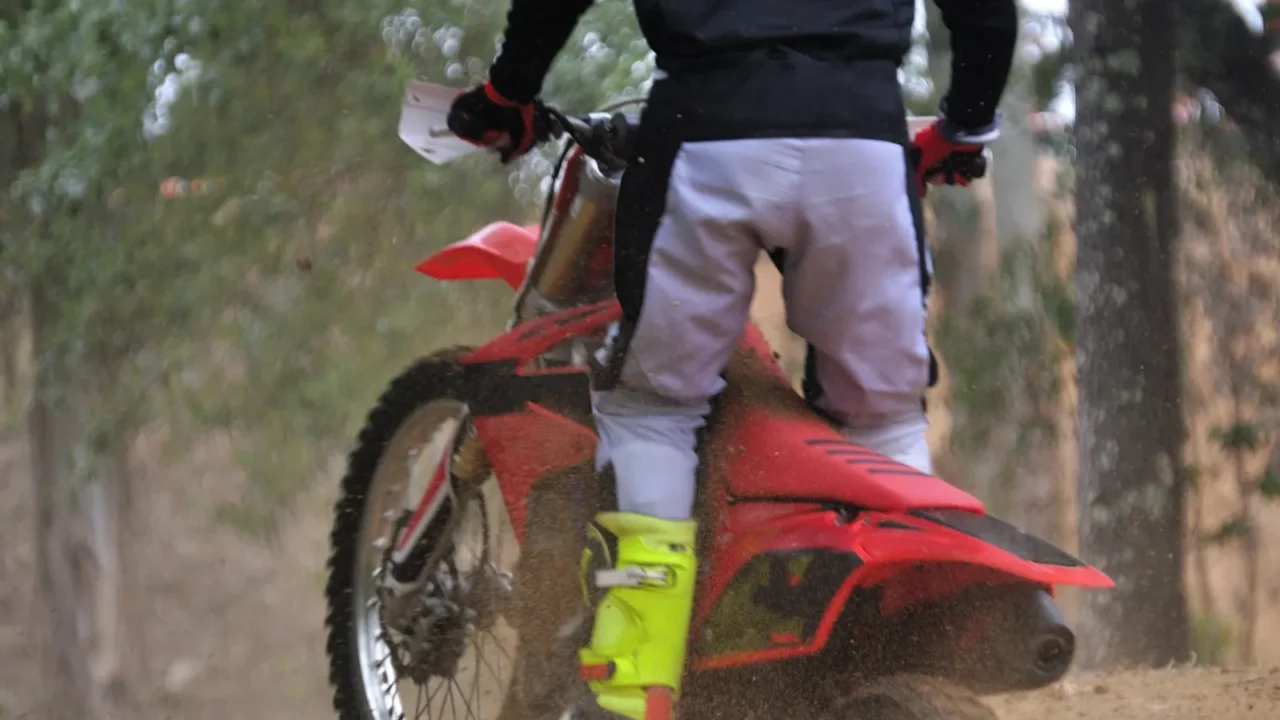 motocross rider climbing a small hill standing on top of
