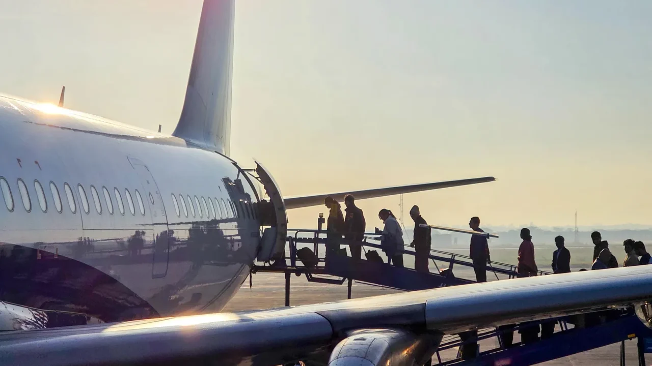 passengers boarding aircraft via a ramp near the tail exit