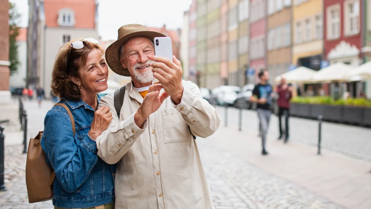 portrait of happy senior couple tourists making selfie outdoors in