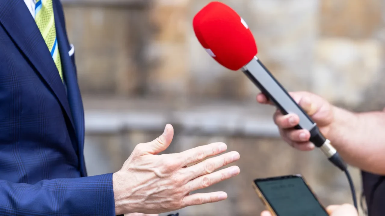 reporter holding microphone making media interview with politician or business