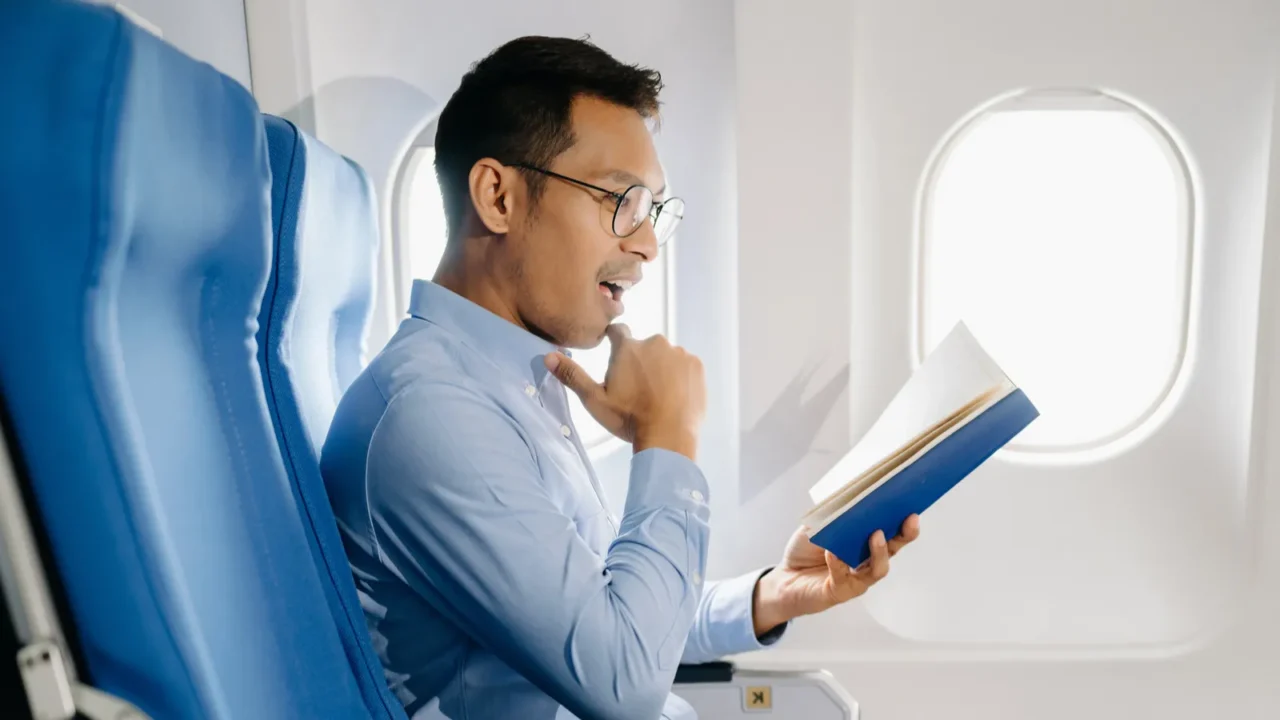 side view of an attractive asian businessman in an airplane