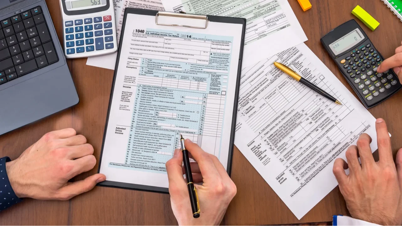 two people filling tax forms helping each other