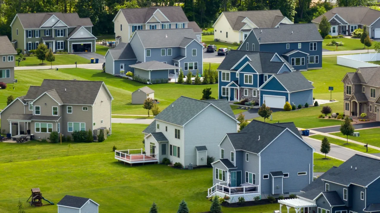 upscale suburban homes with large backyards and green grassy lawns