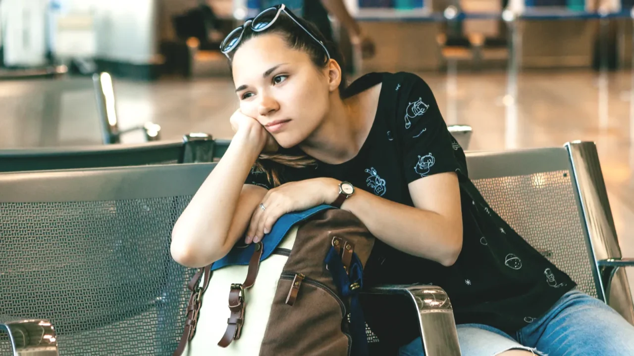 upset or bored girl tourist or student at the airport