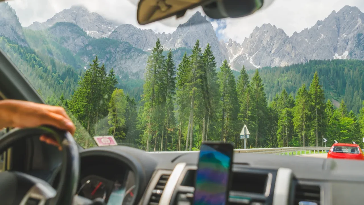 view from car inside navigation on phone mountains on background