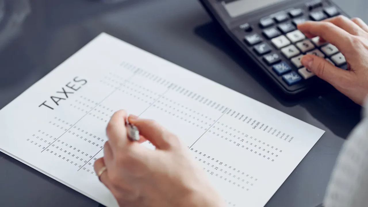 woman accountant using a calculator and laptop computer while counting