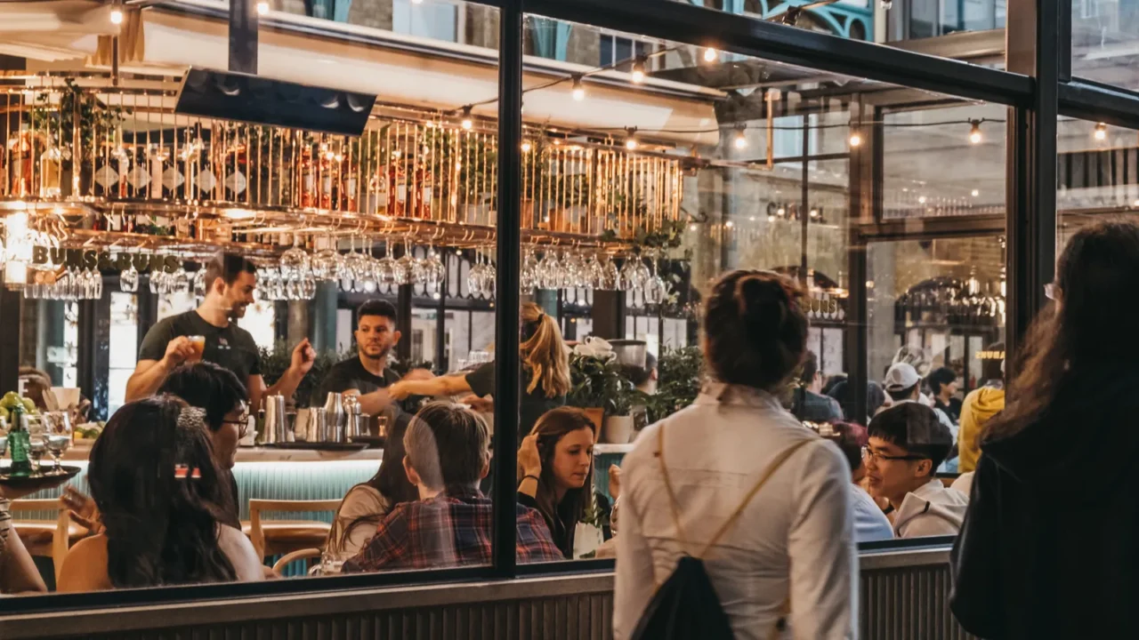 women walking past the windows of buns and buns restaurant