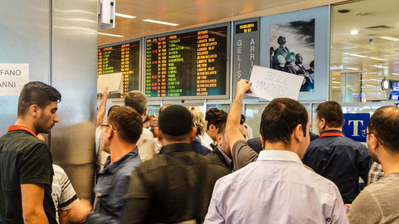 ISTANBUL, TURKEY - MAY 15, 2014 -Arriving passengers run the gauntlet of travel guides as they exit customs area of the airport in Istanbul, Turkey