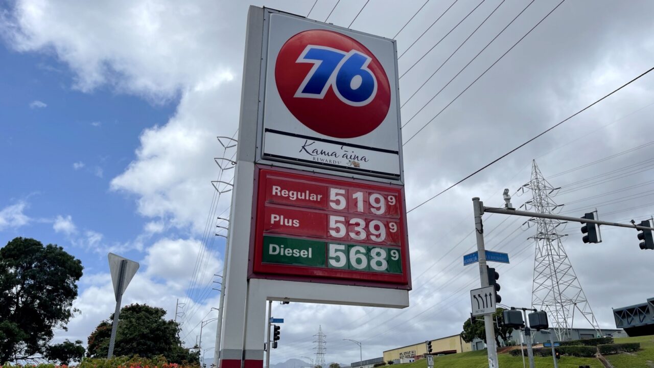 PEARL CITY, UNITED STATES - Apr 05, 2022: A low angle shot of a street sign of gas prices against blue cloudy sky on a sunny day in Pearl City, Oahu, Hawaii, United States