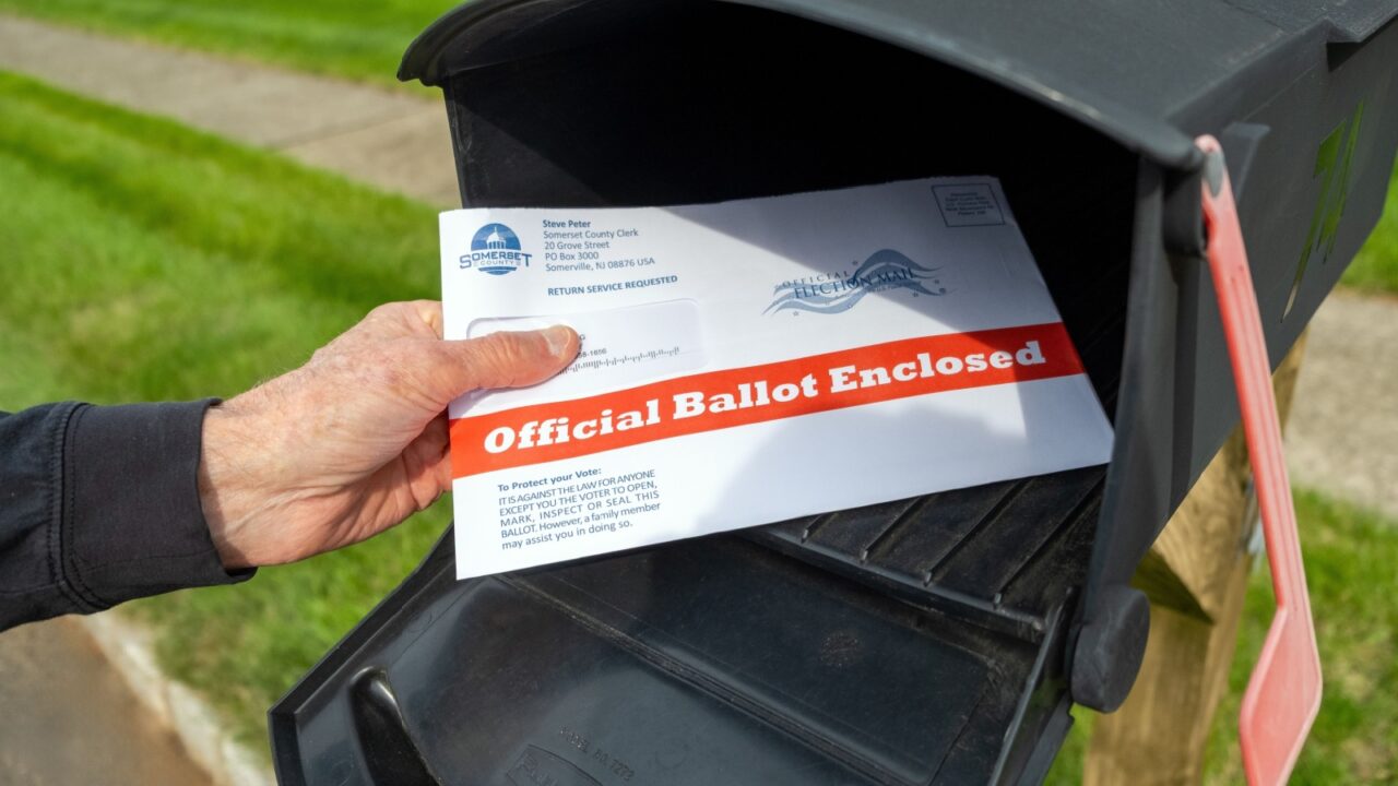 Somerset, NJ, USA - September 25, 2020: Man with mail-in election ballot at mailbox.