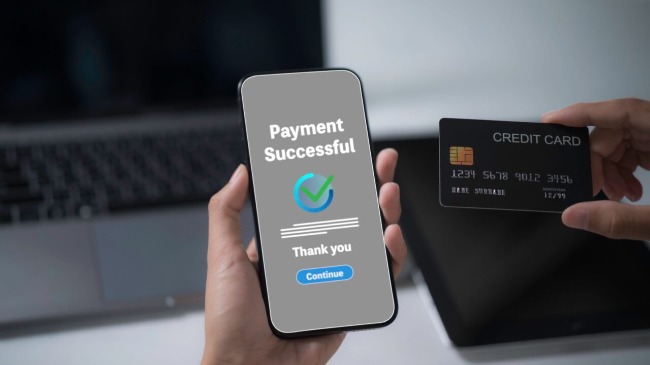 Payment successful concept.Hand holding credit card and smartphone with Payment successful.Online Money Transfer Confirmed.Concept of e-commerce and online banking, payment transfer