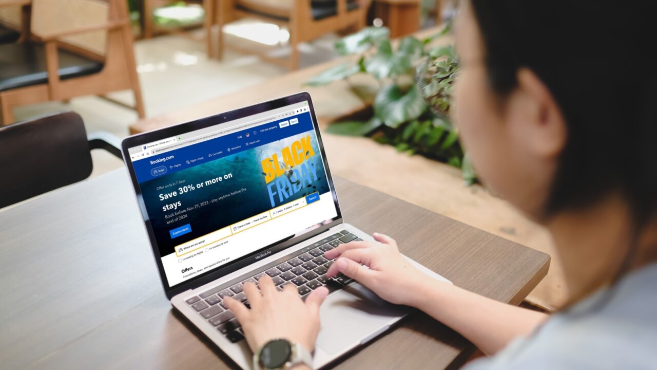 Bangkok, Thailand. DEC 4, 2024; Person browsing Booking.com Black Friday deals page offering 30% discount on stays, viewed on laptop in plant-decorated workspace.