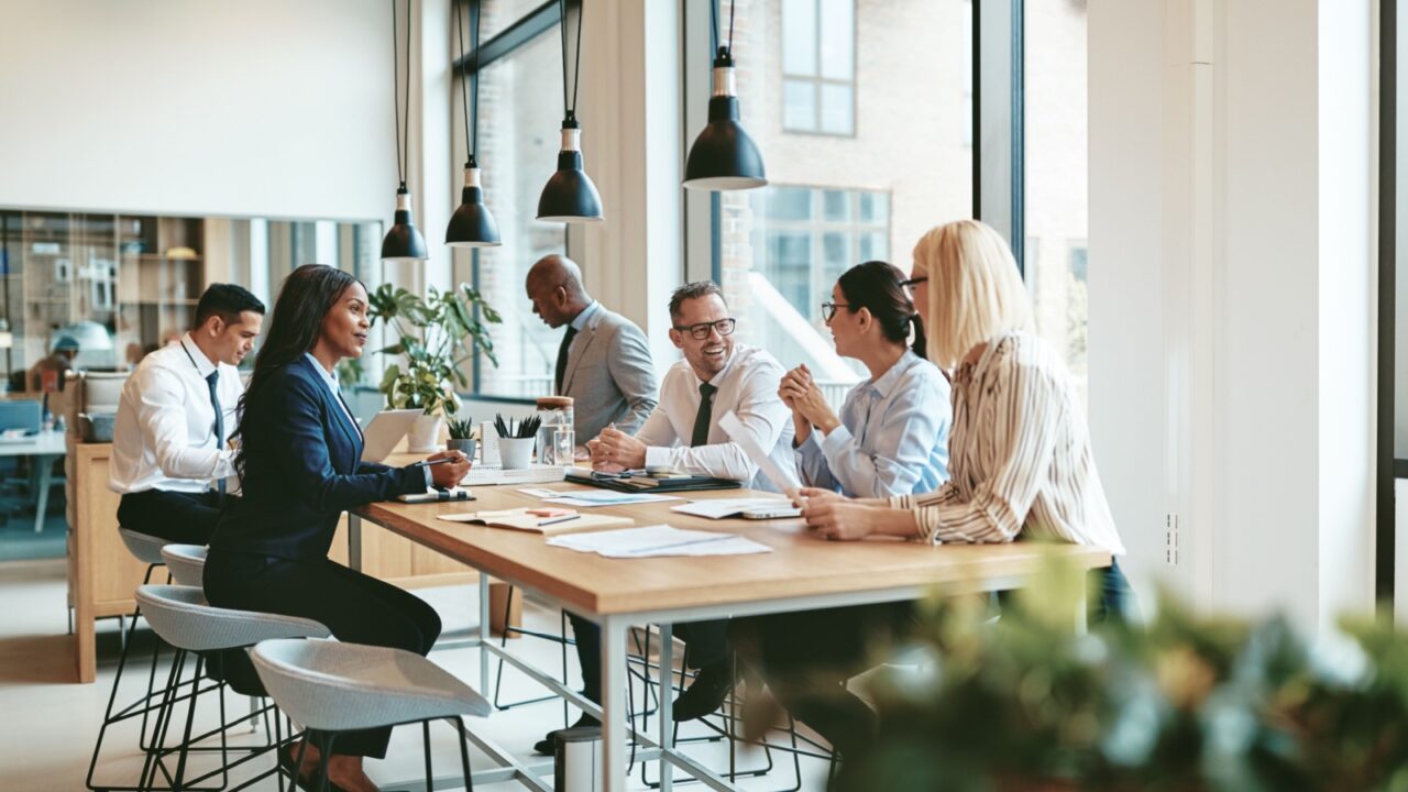 Smiling group of businesspeople together while having a meeting around a table