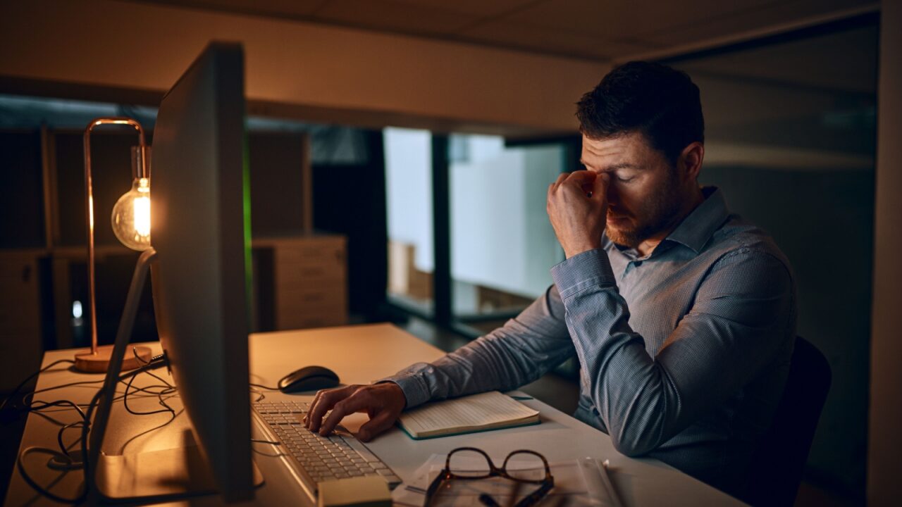 Stressed and overworked employee in the office at night