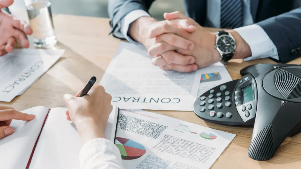 cropped shot of business people having conversation with documents and