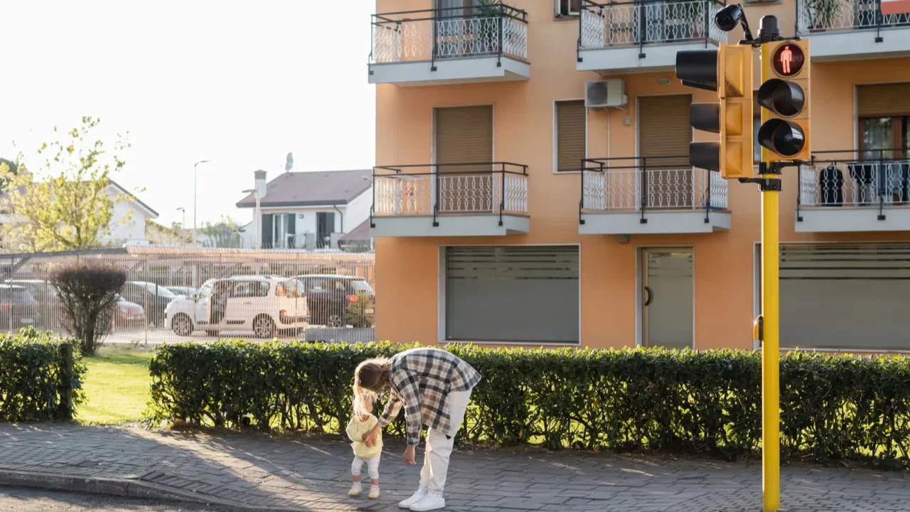 young dad standing near baby girl and crosswalk on urban